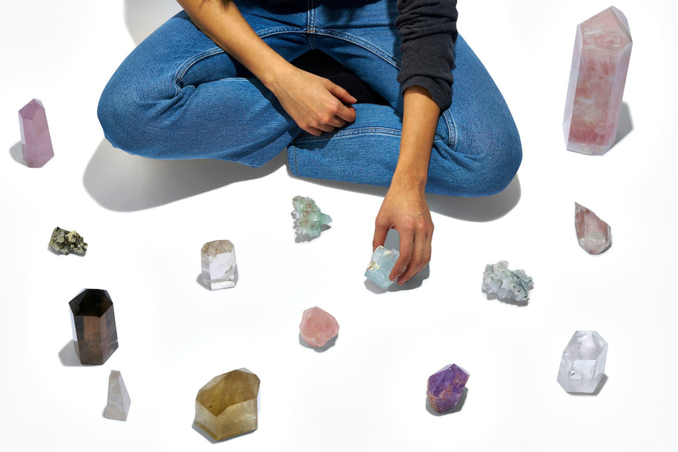 Multiple renoo crystals laid out on the floor in front of a practitioner.