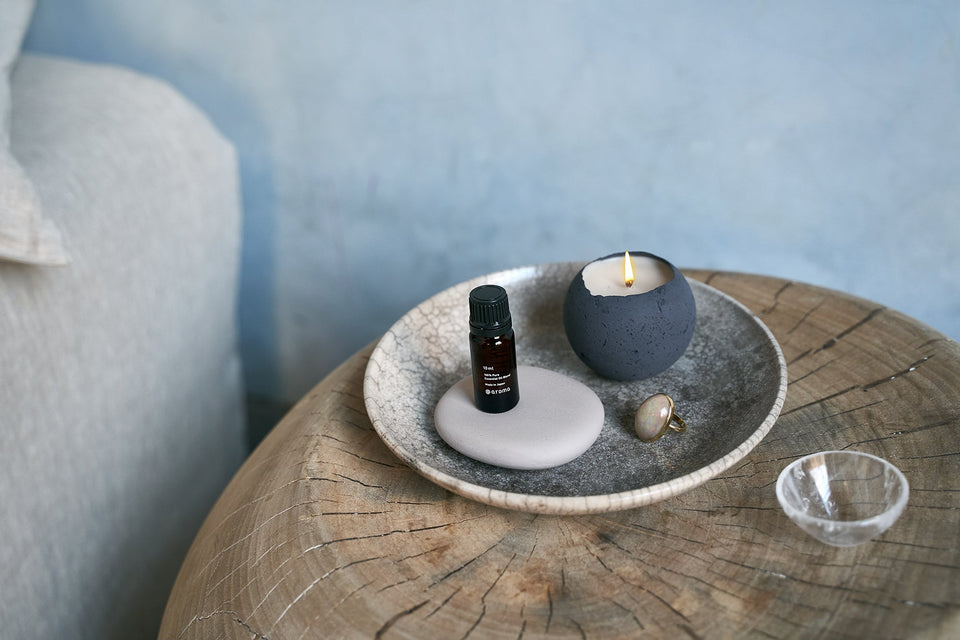 renoo aromatherapy meditation goods set on bedside table. Shown here is essential oil by at aroma along with a Tokoname diffuser and Orbis concrete candle.